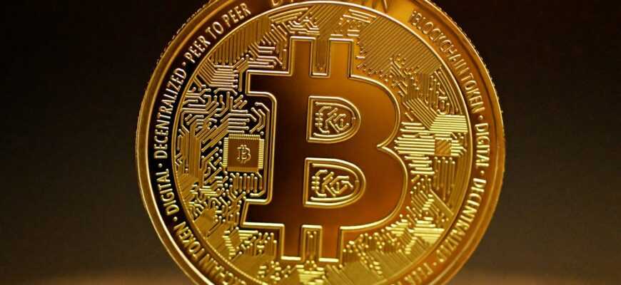 a golden bitcoin sitting on top of a table