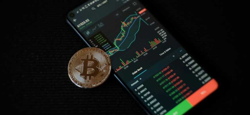 a bitcoin sitting on top of a smart phone